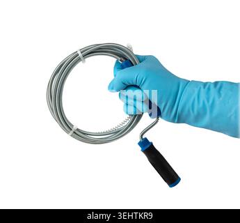 Metal drain auger tool isolated, plumbing snake or cable in hands in blue glove on white background, removing sink blockages Stock Photo
