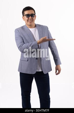 Confident handsome young Asian businessman gesturing with open hand welcome Stock Photo