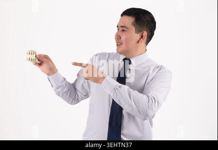Young smiling Asian businessman pointing finger toward copy space sideways Stock Photo