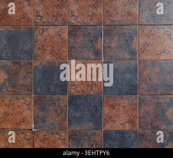 Square stone tiles with gradient colors between dark brown and black. Full frame, background and texture. Stock Photo
