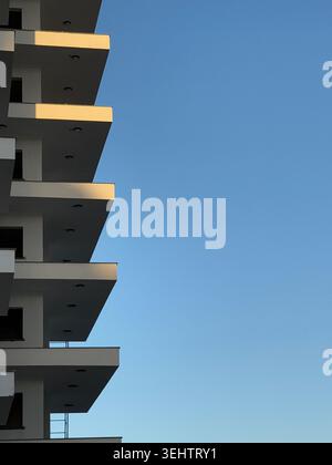 Modern architectural building with geometric design against clear blue sky, suitable as background. Mobile photo Stock Photo