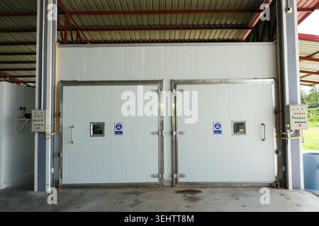 Large white door of an industrial cold storage freezer room in commercial warehouse factory facility presenting sterile and efficient atmosphere for m Stock Photo