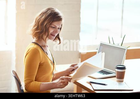 Business woman, checking documents or laptop with folder for financial planning or budget in office. Female person, accountant or reading with Stock Photo