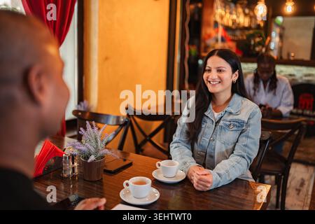 Smiling woman enjoying coffee with partner during casual date Stock Photo