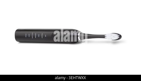 Black electric toothbrush resting on a white background, highlighting dental care and technology Stock Photo