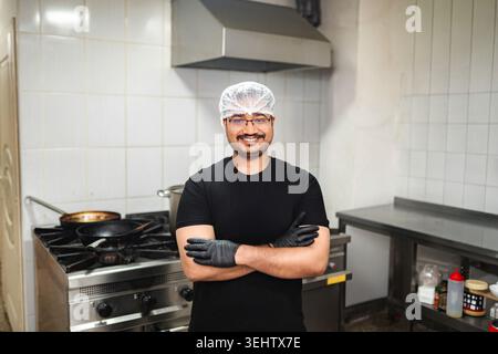 Smiling professional chef standing in commercial kitchen Stock Photo