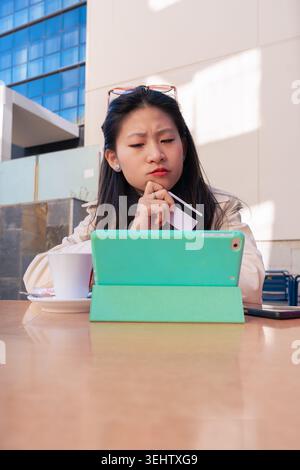 Focused person using a tablet and credit card for secure online shopping outdoors. Stock Photo