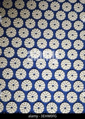 The surface displays many circular designs evenly spaced on a blue background, highlighting an urban texture used in textiles. Stock Photo