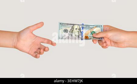 100 dollar. Man giving dollar banknotes to woman. Male hand holding 100 dollar cash bills passing it on to another person. Stock Photo