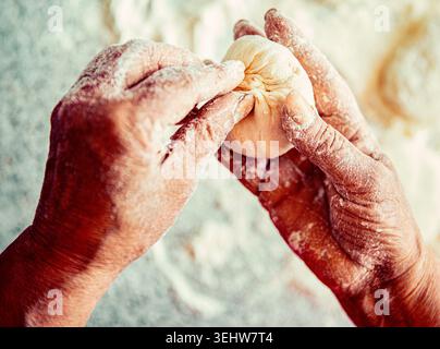 Cakes dough in the women's hands. Process of making pies, hand. Hands pie dough. Cooks dough for baking Stock Photo