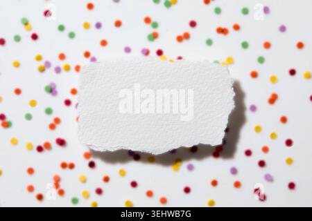 Torn white paper on confetti background Stock Photo
