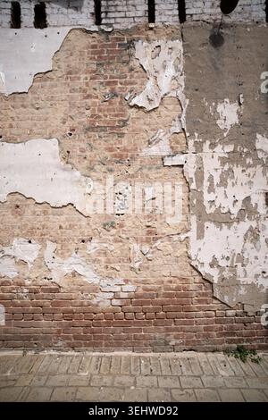 Weathered brick wall and peeling plaster Stock Photo