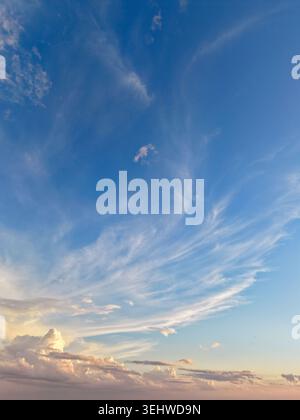Wispy clouds and dazzling blue sky near sunset Stock Photo