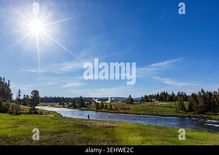 Sun on blue sky over Firehole River Stock Photo