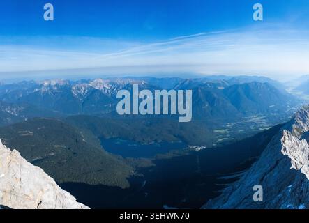This panoramic shot captures a breathtaking view of the Bavarian Alps, likely viewed from a high peak overlooking the Zugspitze and the surrounding Zu Stock Photo