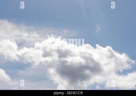 Blue Sky with White Cumulus Clouds on a Sunny Day. Sunny Sky. Nature Background. Peaceful Atmosphere. High quality photo Stock Photo