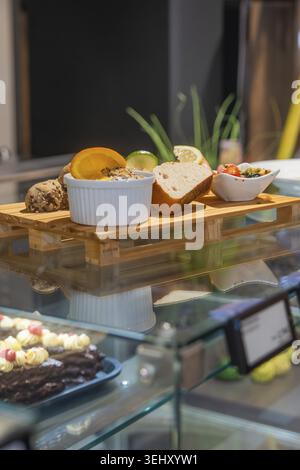 Different types of bread and spreads on a wooden tray in a modern glass display case, breakfast at Cafe Kuh, Deckenpfronn, Germany Stock Photo