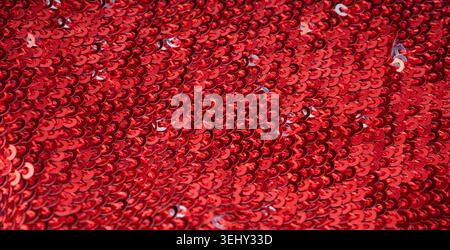 Sequin fabric macro texture, color shiny carnival background. Red glitter dress pattern, decorative metallic material design close up Stock Photo