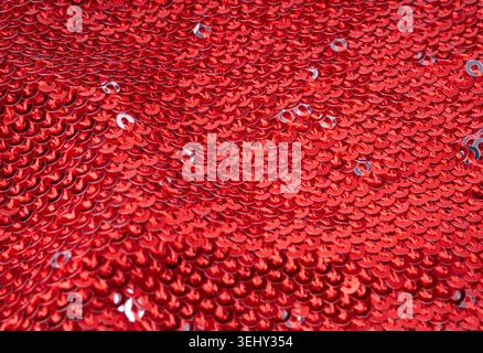 Sequin fabric macro texture, color shiny carnival background. Red glitter dress pattern, decorative metallic material design close up Stock Photo
