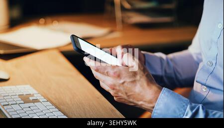 Businessman, hands and typing with phone screen in night for communication or schedule in office. Closeup, man or employee on mobile smartphone in Stock Photo