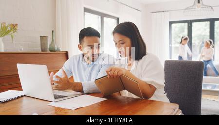 Financial planning, online and couple with tablet, home and budgeting for family security on website. Talking, man and woman with laptop for risk Stock Photo