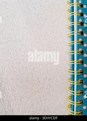 Blue polka dot spiral notebook with a bright yellow binding on a textured white background, providing useful copy space Stock Photo