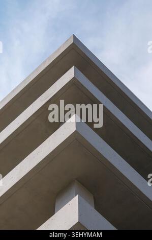 Close up architectural detail of a modern brutalist concrete building exterior. Minimalist geometric pattern of raw cement walls, sharp lines, light a Stock Photo