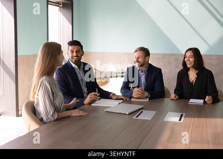 Diverse businesspeople laughing discussing strategy at corporate meeting Stock Photo