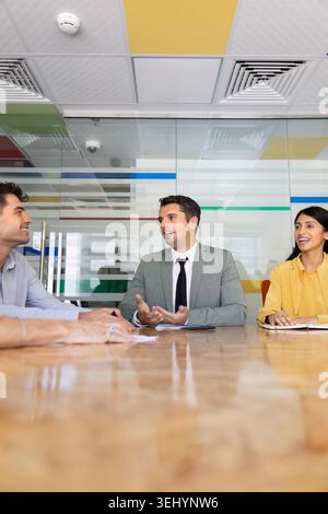 Businessman leading discussion with diverse team during meeting Stock Photo