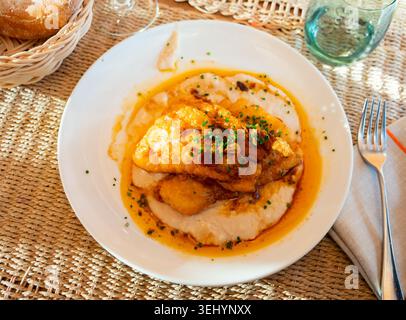 Fried cod with creamy white beans and gravy Stock Photo