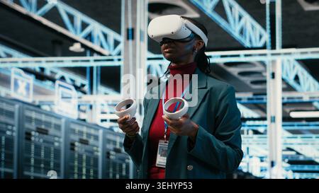 VR headset gear, AR simulation and system administrator in data center managing database storage rigs. Cloud computing, VFX visualization and worker in server room using virtual reality tech, camera B Stock Photo
