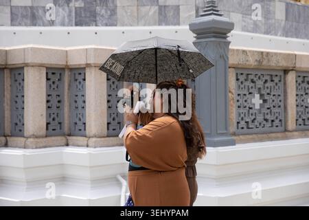 BANGKOK, THAILAND-MAY 16, 2026: Female tourist using digital camera, traveler using camera while visiting famous destination, side profile. Stock Photo