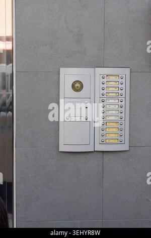 Apartment building intercom system featuring a camera, speaker, and numerous resident doorbells Stock Photo