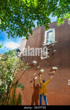 Painted mural depicting falling paper in L'isle sur la Sorgue in Provence France Stock Photo