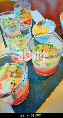 Several oyster shooters in a glass on a restaurant table. Stock Photo