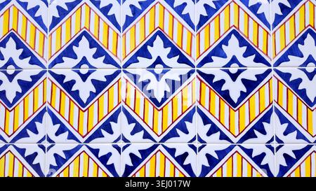 A close-up view of classic Portuguese glazed ceramic tiles, displaying a repeating diamond pattern. The glossy, smooth surface reflects light, emphasi Stock Photo
