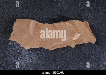 Horizontal Torn Kraft Paper Strip on Dark Background Stock Photo