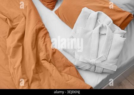 Folded waffle bathrobes on bed in room, top view Stock Photo