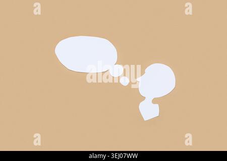 Paper human head with blank speech bubbles on color background Stock Photo