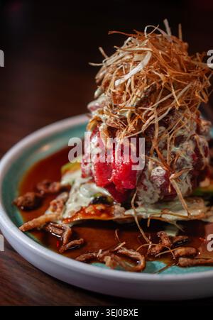 wonton cracker with fresh tuna cubes and fried onions with celery and garlic cream. Stock Photo