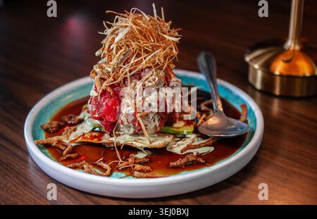 wonton cracker with fresh tuna cubes and fried onions with celery and garlic cream. Stock Photo