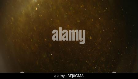 Twinkle blur confetti. Flare glimmer. Yellow gray mixing flow. Golden shimmering light color particles on dark abstract background. Stock Photo