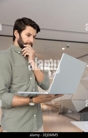 Focused businessman analyzing financial data on laptop Stock Photo