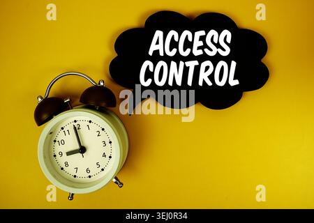 Access Control text with alarm clock on yellow background Stock Photo