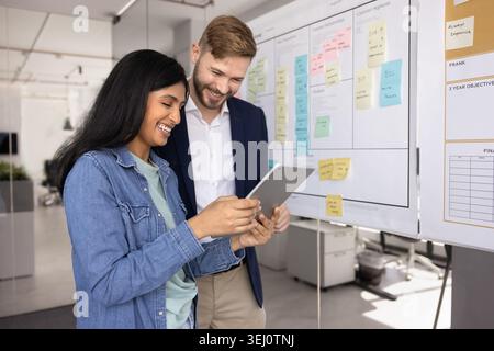 Teammates using tablet working together in office Stock Photo