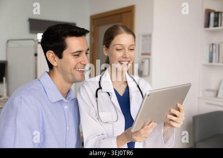 Doctor and patient reviewing digital results on tablet Stock Photo
