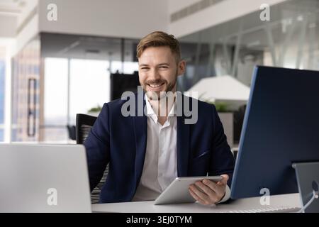 Businessman working at modern office desk with computer and tablet Stock Photo