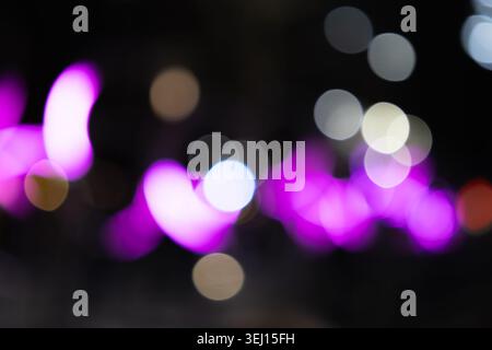 Defocused neon purple lights glowing in the night Stock Photo