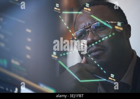 Close up of Black young adult man analyzing network data on computer screen, reflecting cybersecurity monitoring and IT infrastructure management. Ideal for tech services marketing Stock Photo