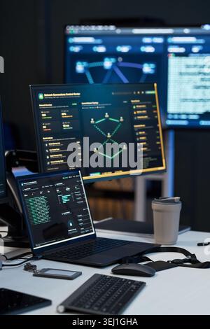 Vertical shot of cybersecurity workstation displaying network monitoring dashboards, code logs, data analysis screens. Supporting IT security, threat detection, SOC marketing, vertical Stock Photo